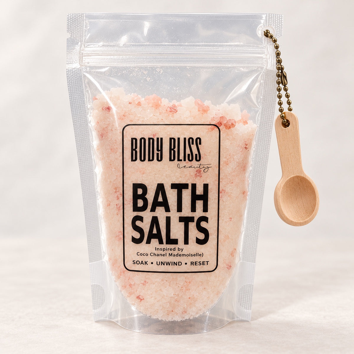 Body Bliss Mademoiselle Inspired Bath Salts in a clear pouch with wooden scoop