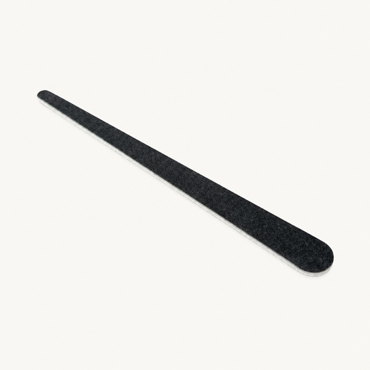 Single black Body Bliss tear drop nail file on a warm ivory background