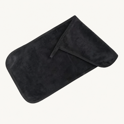 One folded black Body Bliss cleansing makeup remover cloth on a warm ivory background