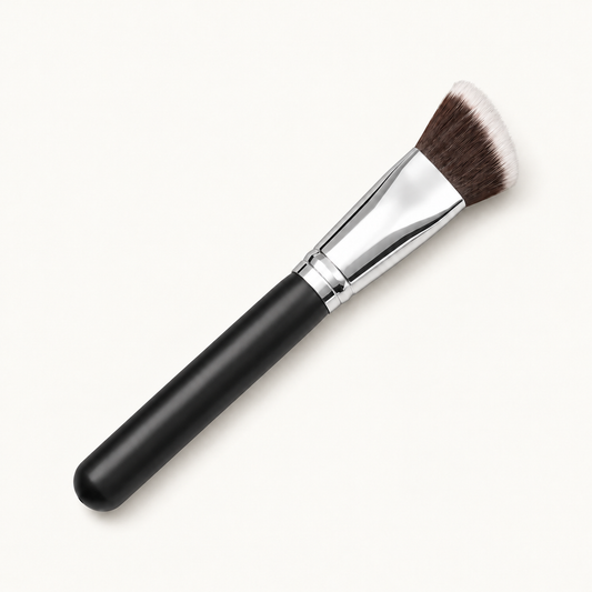 Bliss foundation brush with black handle and silver ferrule on a warm ivory background