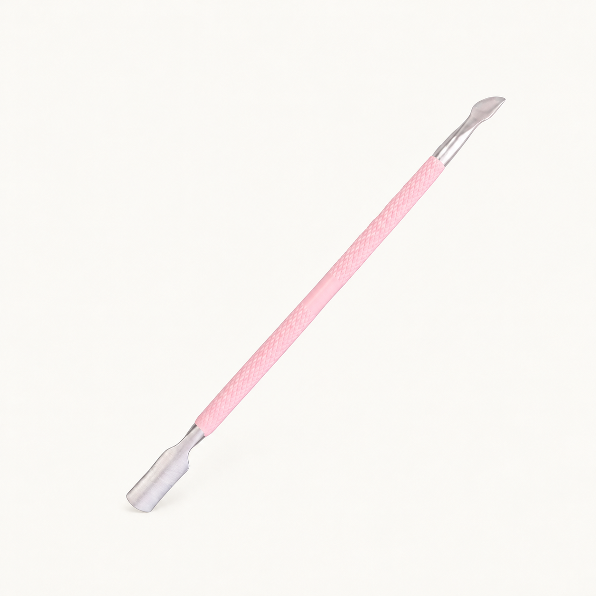 One Body Bliss double-ended cuticle pusher with a pink grip and silver ends on warm ivory
