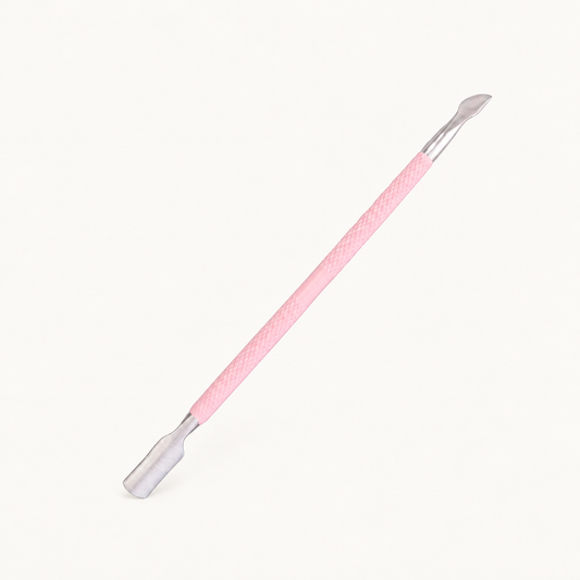 One Body Bliss double-ended cuticle pusher with a pink grip and silver ends on warm ivory