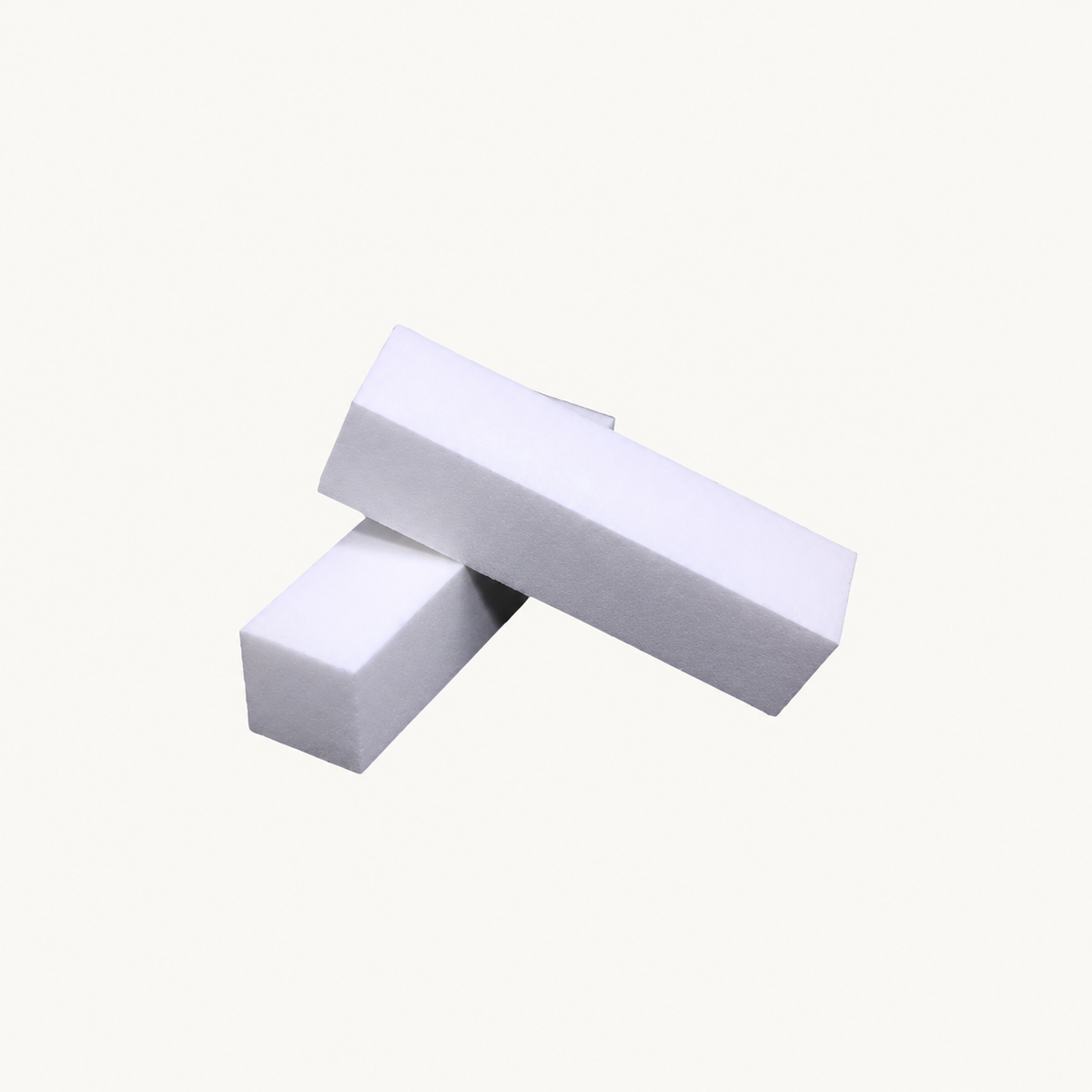 Two white Body Bliss buffing blocks on a warm ivory background
