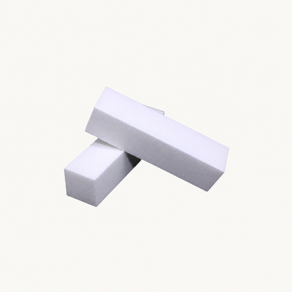 Two white Body Bliss buffing blocks on a warm ivory background