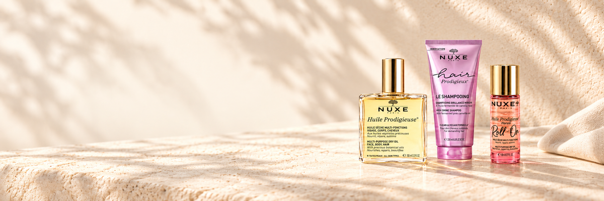 NUXE Original dry oil, Hair Prodigieux shampoo and Florale roll-on in warm sunlight.